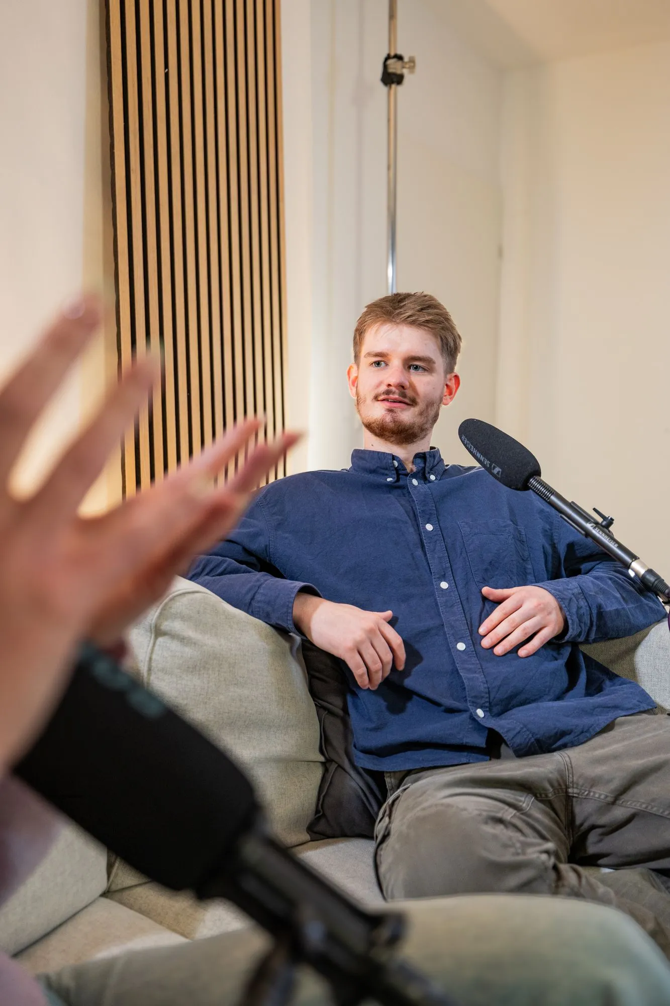 Gast eines Unternehmenspodcasts mit Mikrofon im Studio Essen
